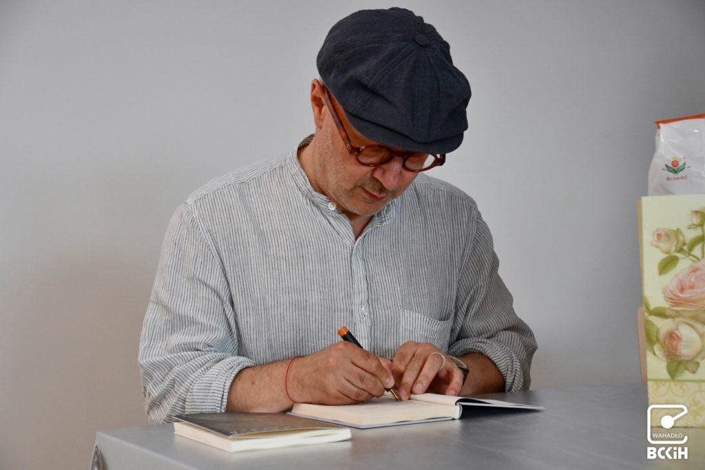 Mikołaj Grynberg podpisujący książkę